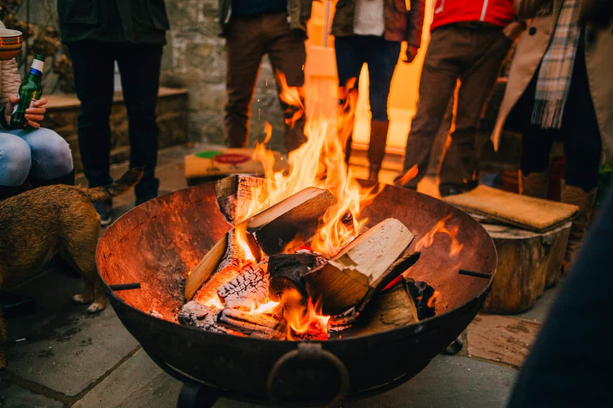 Image of a group of people conscious about fire pit safety enjoying a fire on a cool fall evening.