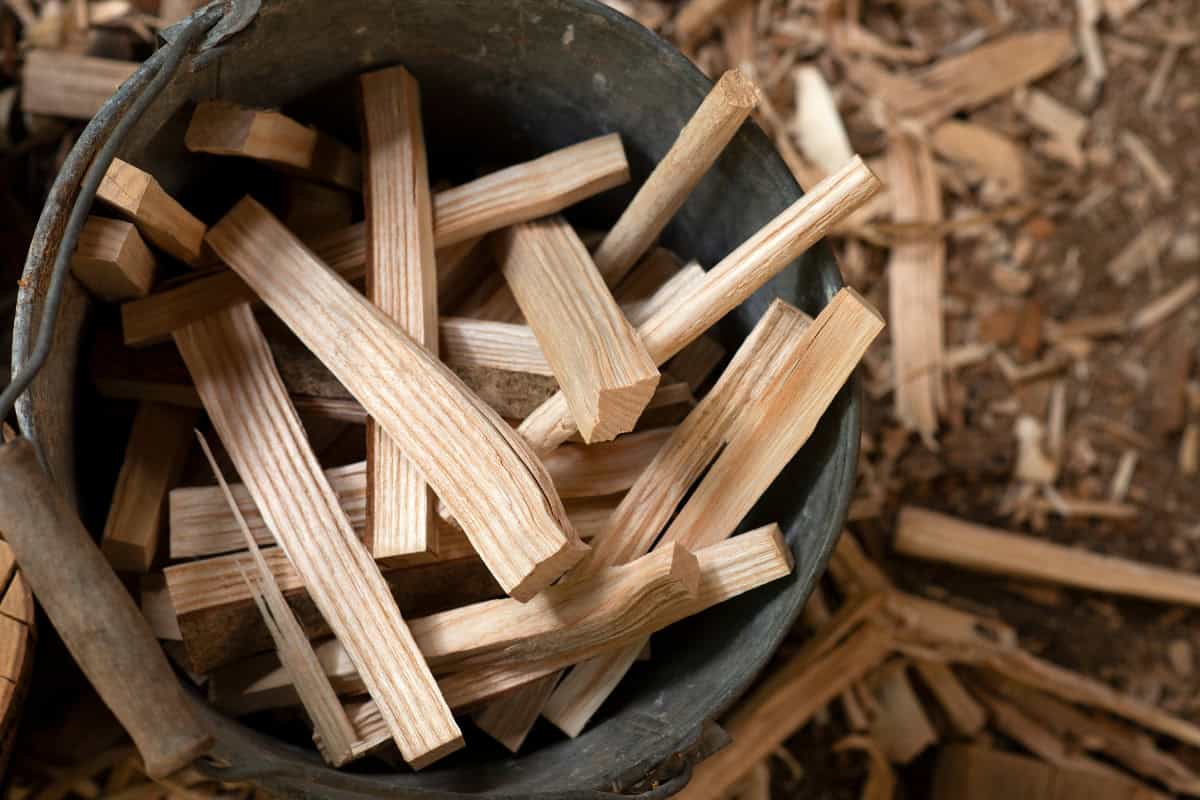 start-a-fire-pit-fire-gather Image of a metal bucket filled with thin wooden kindling sticks for starting a fire pit.