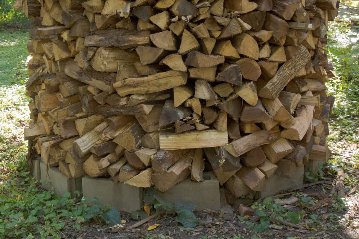 Image of wood stacked in Holz-hausen form for a blog post on how to stack firewood.