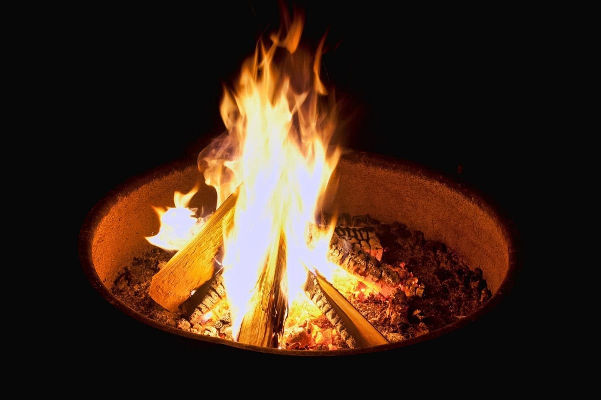 how-to-start-a-fire-pit-closing Image of a fire pit fire at night for a blog post about how to put out a fire pit.