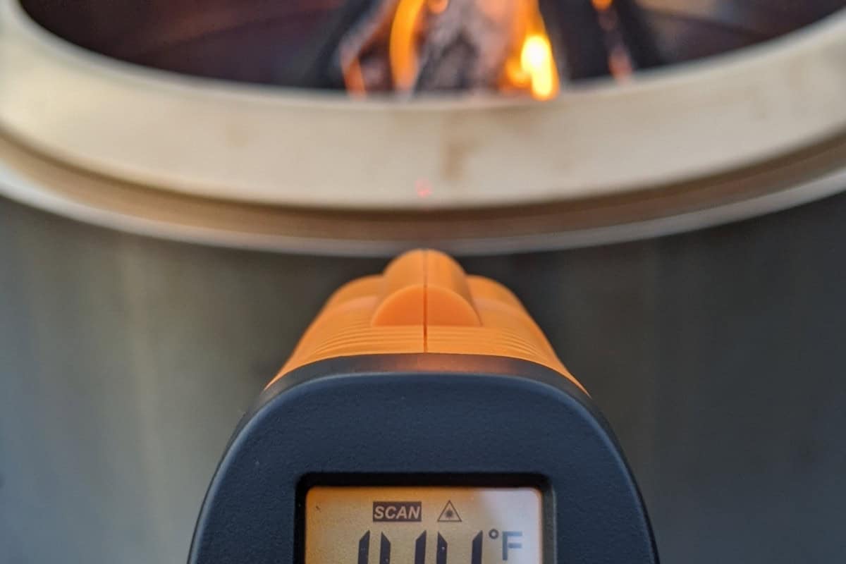 smokeless-fire-pit-advantages-safety Image of a infared thermometer measuring the external temp of a burning fire pit.