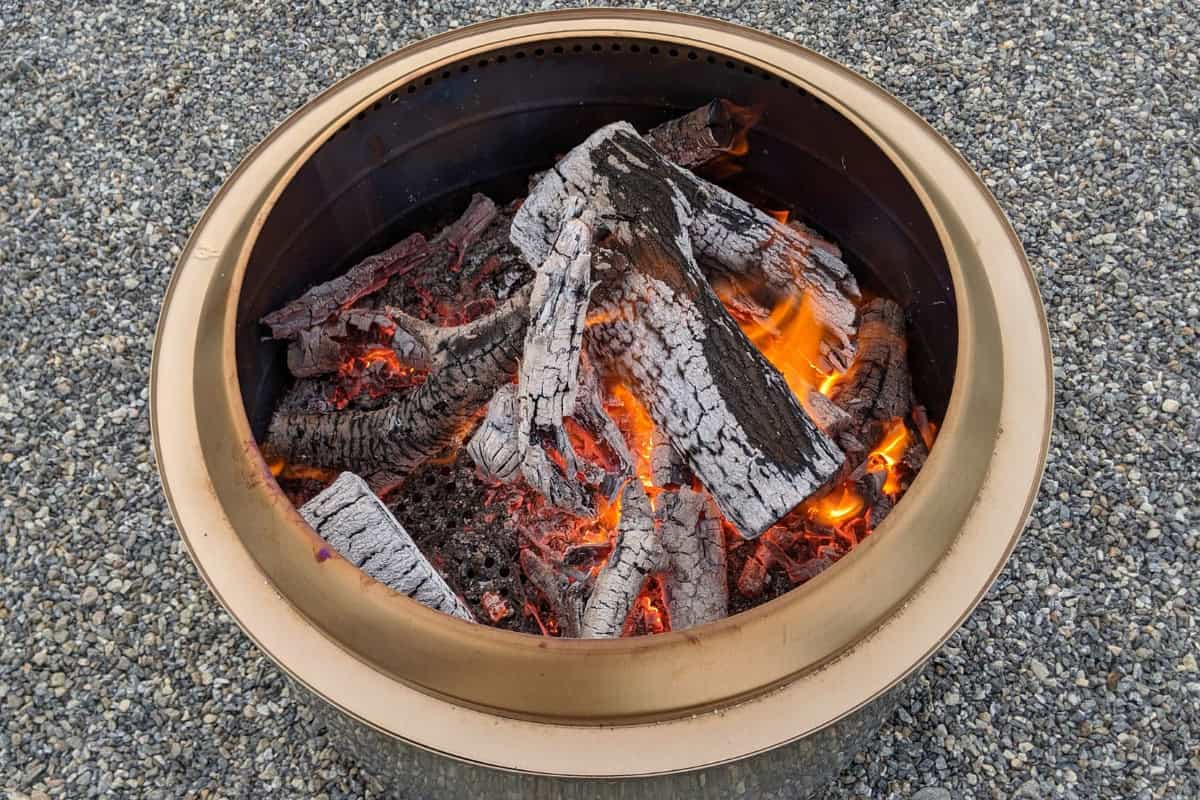 smokeless-fire-pit-advantages-what Image of a burning Solo Stove Yukon on a stone driveway.