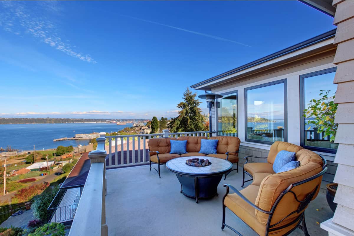 Image of a tiled round propane fire pit on a seaside home's balcony.