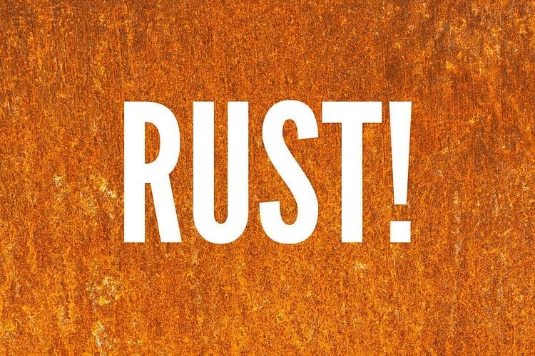 Image of the word rust with a rusty fire pit background