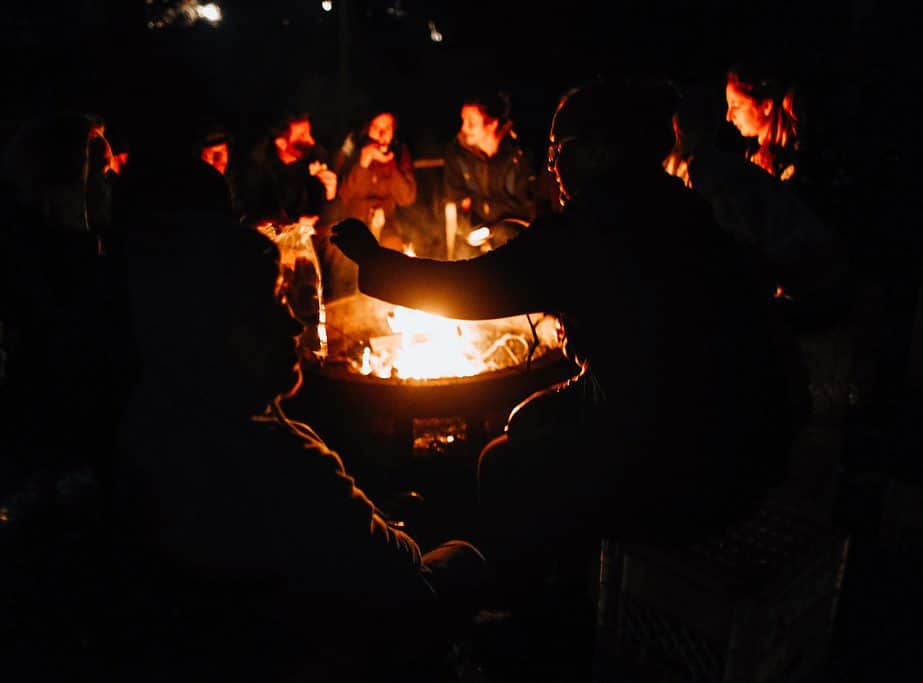Image a of group of people around a fire pit at night