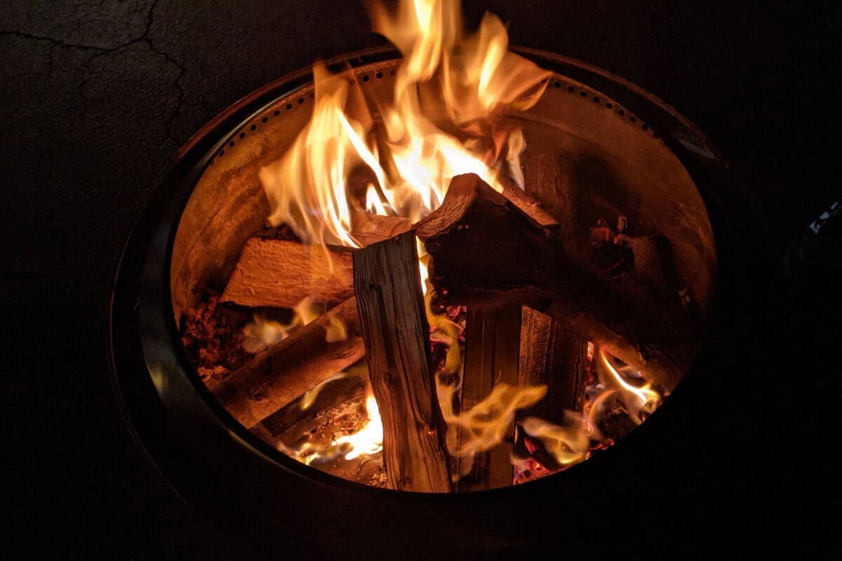 Image of a smokeless fire pit burning at night for a blog post about using a solo stove on a composite deck.