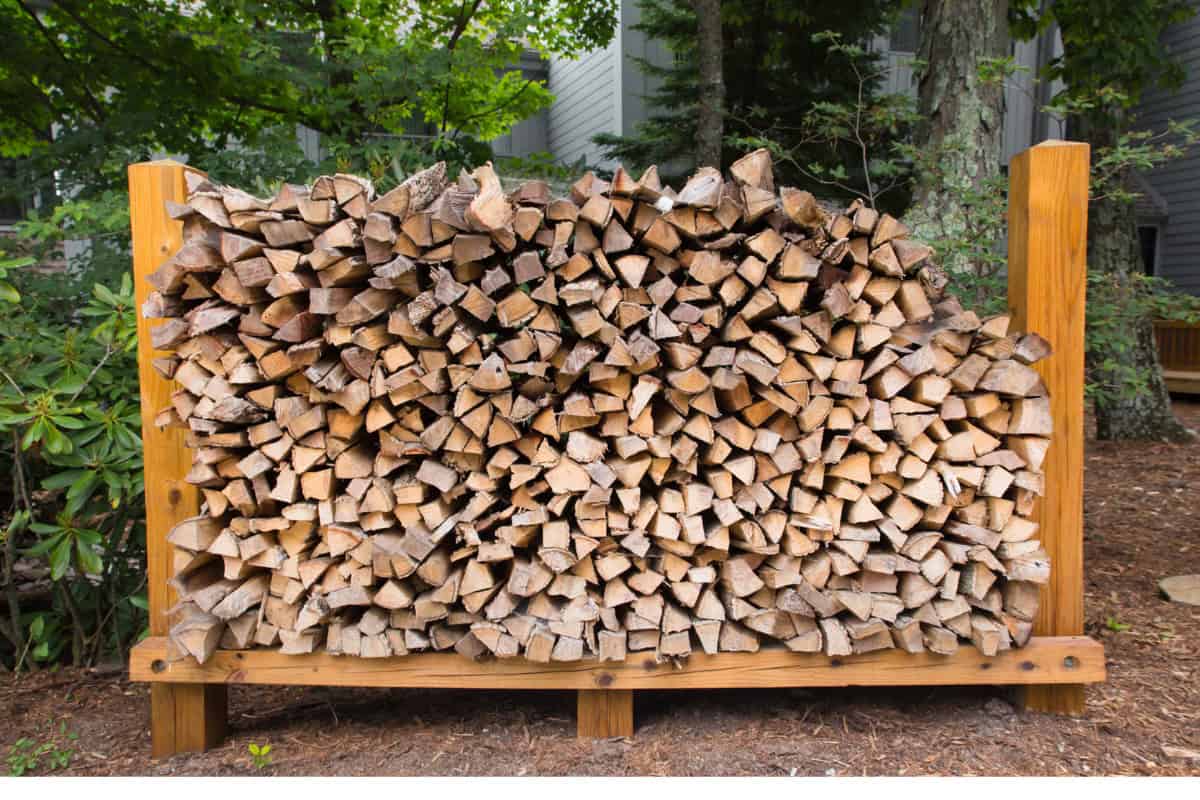 Image of split firewood stacked in a homemade wood rack.