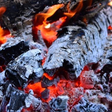 Image of hot fire pit ash and embers for a blog post covering how to dispose of fire pit ash.
