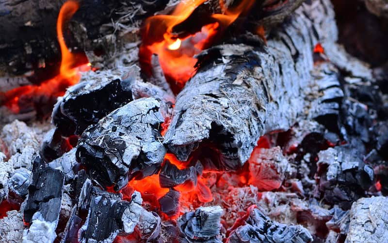 Image of hot fire pit ash and embers for a blog post covering how to dispose of fire pit ash.