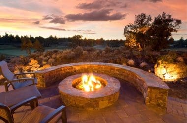 Image of a stone block fire pit at dusk for a blog post about fire pit adhesives.