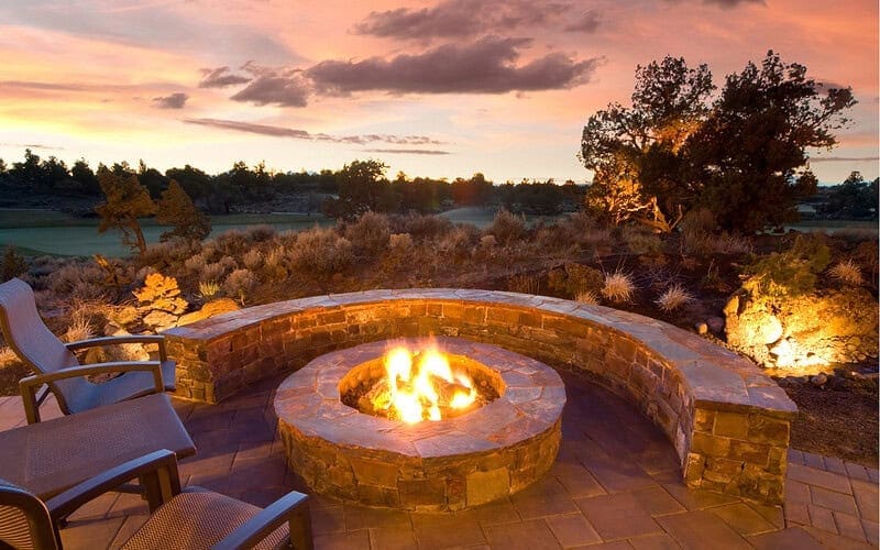 Image of a stone block fire pit at dusk for a blog post about fire pit adhesives.