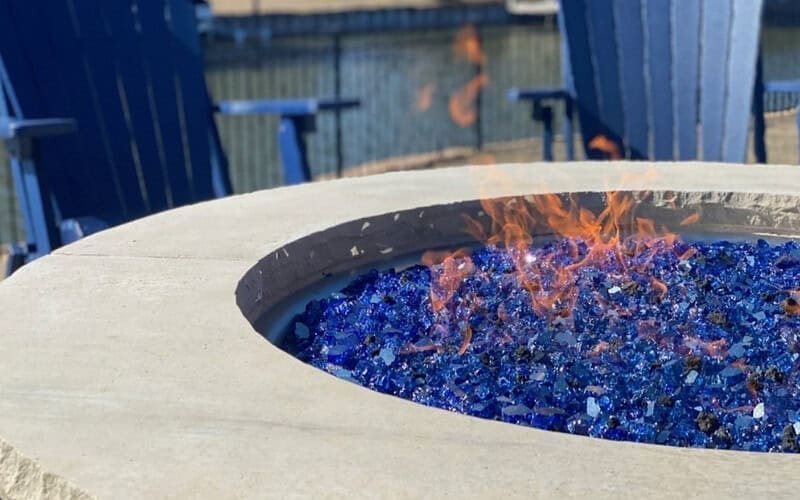Image of a gas fire pit with blue glass for an article covering fire pit glass.