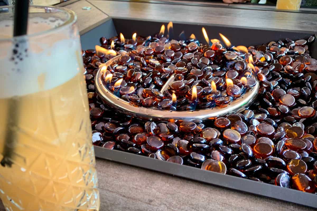 Image of amber colored fireglass in a square fire pit table.
