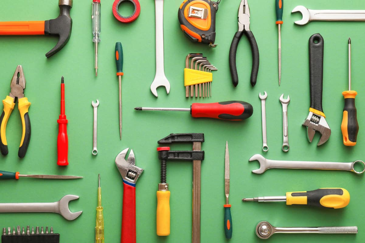 Image of multiple hand tool types on a green background.