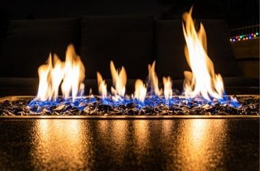 Image of a linear fire pit burning at night for a blog post answering the question "what is the safest fire pit?"