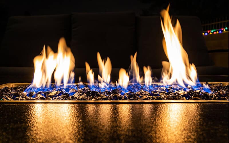 Image of a linear fire pit burning at night for a blog post answering the question "what is the safest fire pit?"