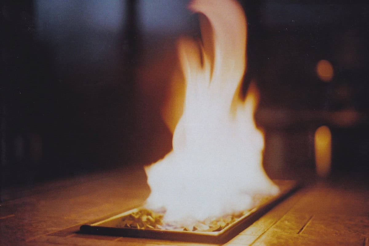 Image of a linear gas fire pit burning after dark.