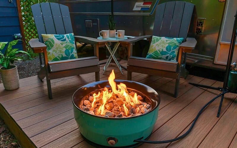 Image of a portable gas fire pit on composite decking for a blog post that answers the question, "how many fire pit btus do I need?"