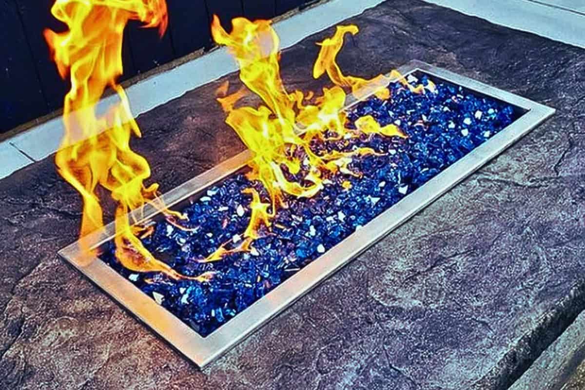 How to Calculate the BTUs You Need for Your Fire Pit Image of a gas fire pit burner with blue fire glass.