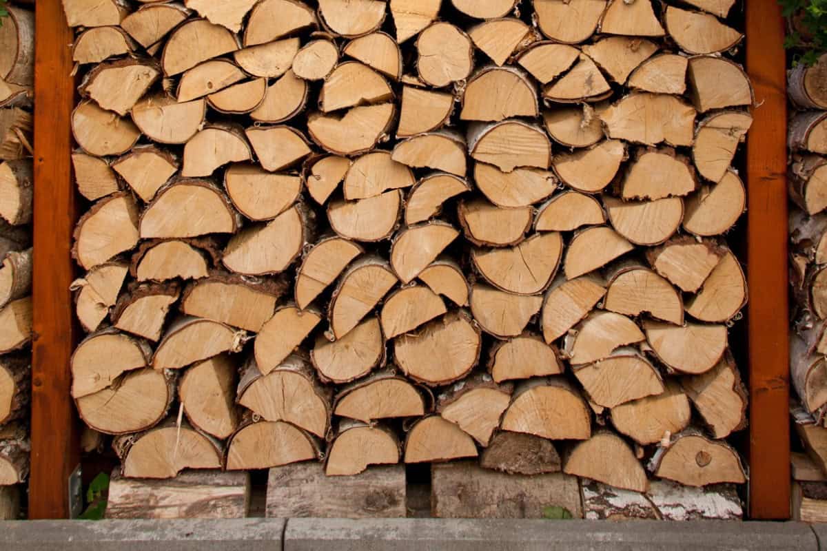 Image of chopped firewood in a rack for a blog post covering the best smelling firewood for fire pits.
