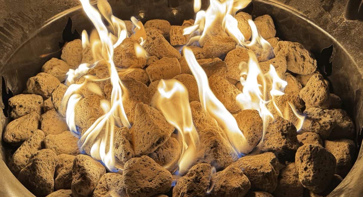 Image of a burning gas fire pit at night for a product review of the Outland Living Mega portable gas fire pit.