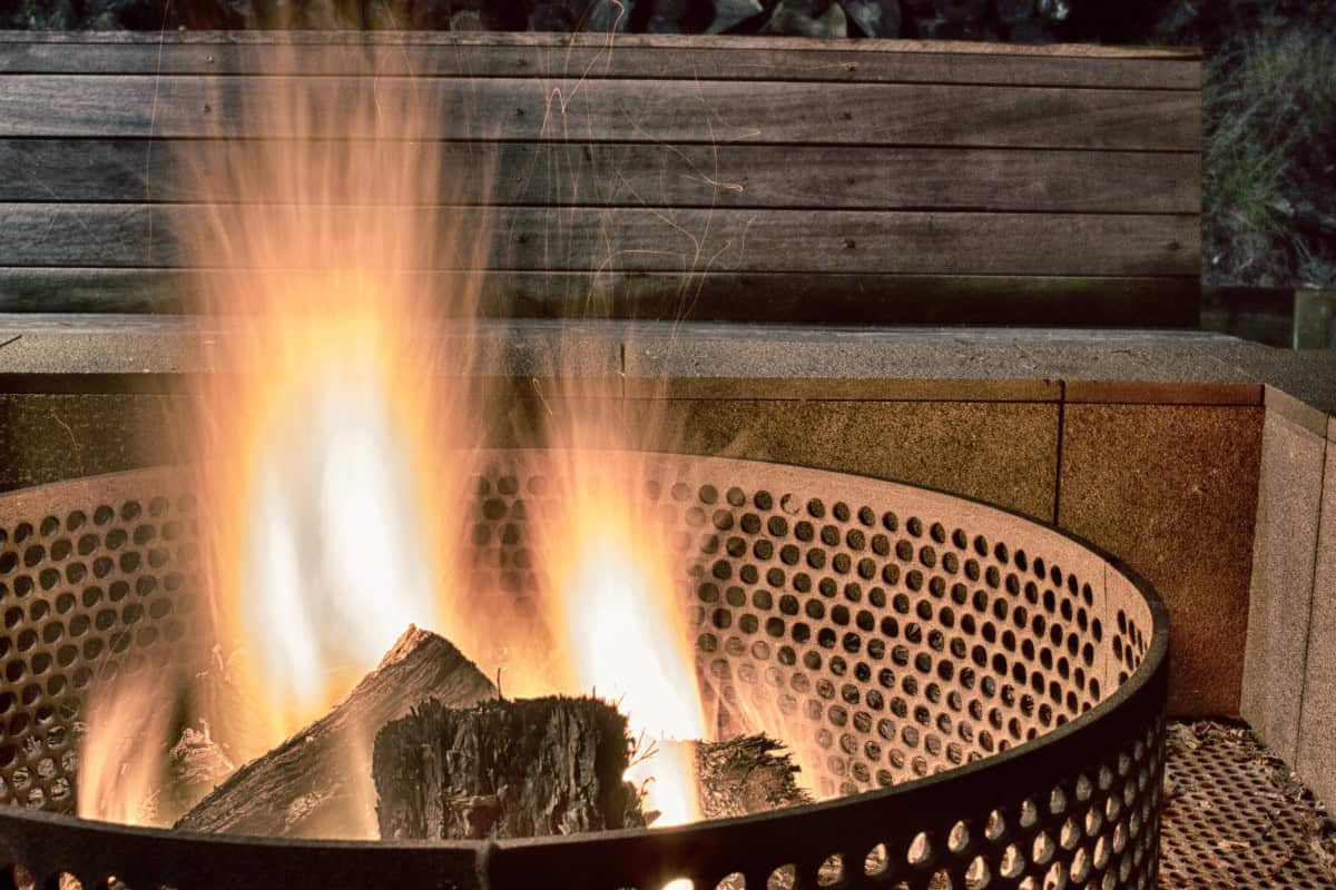 Image of an urban fire pit burning at night for a guide covering city fire pit rules.