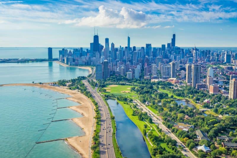 Vibrant aerial view of Chicago skyline with Lake Michigan, city park, and lush greenery, showcasing urban landscapes and outdoor recreation opportunities in a bustling metropolitan area.