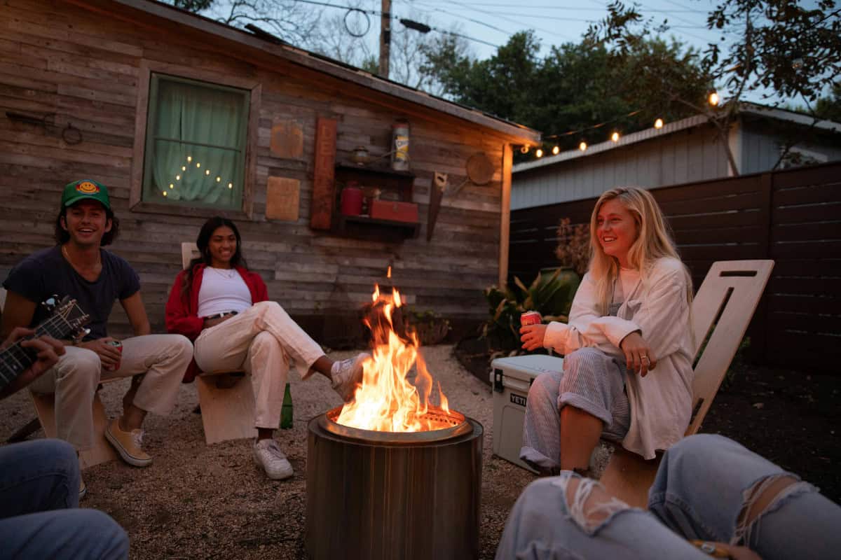Image of a group of friends sitting around a fire at night.