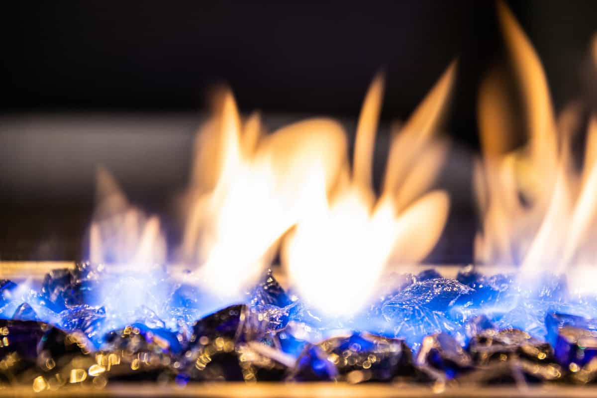 Image of a burning gas fire pit with black fire rock for a post about why a gas fire pit keeps going out.