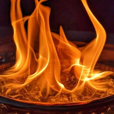 Image of a gas fire pit burner at nigh for an article covering why a gas fire pit keeps going out.