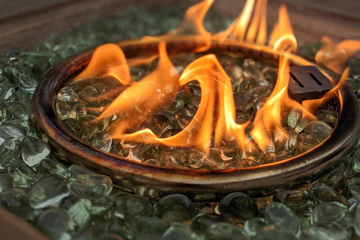 Image of a gas fire pit burner and fire glass.