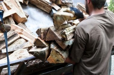 Image of a man delivering firewood to a home for a post on UK firewood prices.